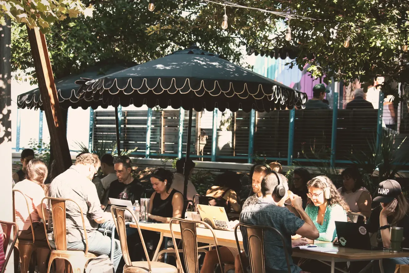 ATX Writing Club members writing at outdoor tables in Austin